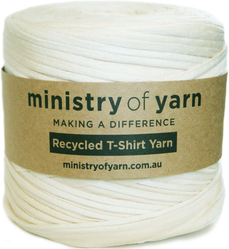 A spool of off-white recycled T-shirt yarn wrapped with a brown paper label that reads 'ministry of yarn' and 'Recycled T-Shirt Yarn'.