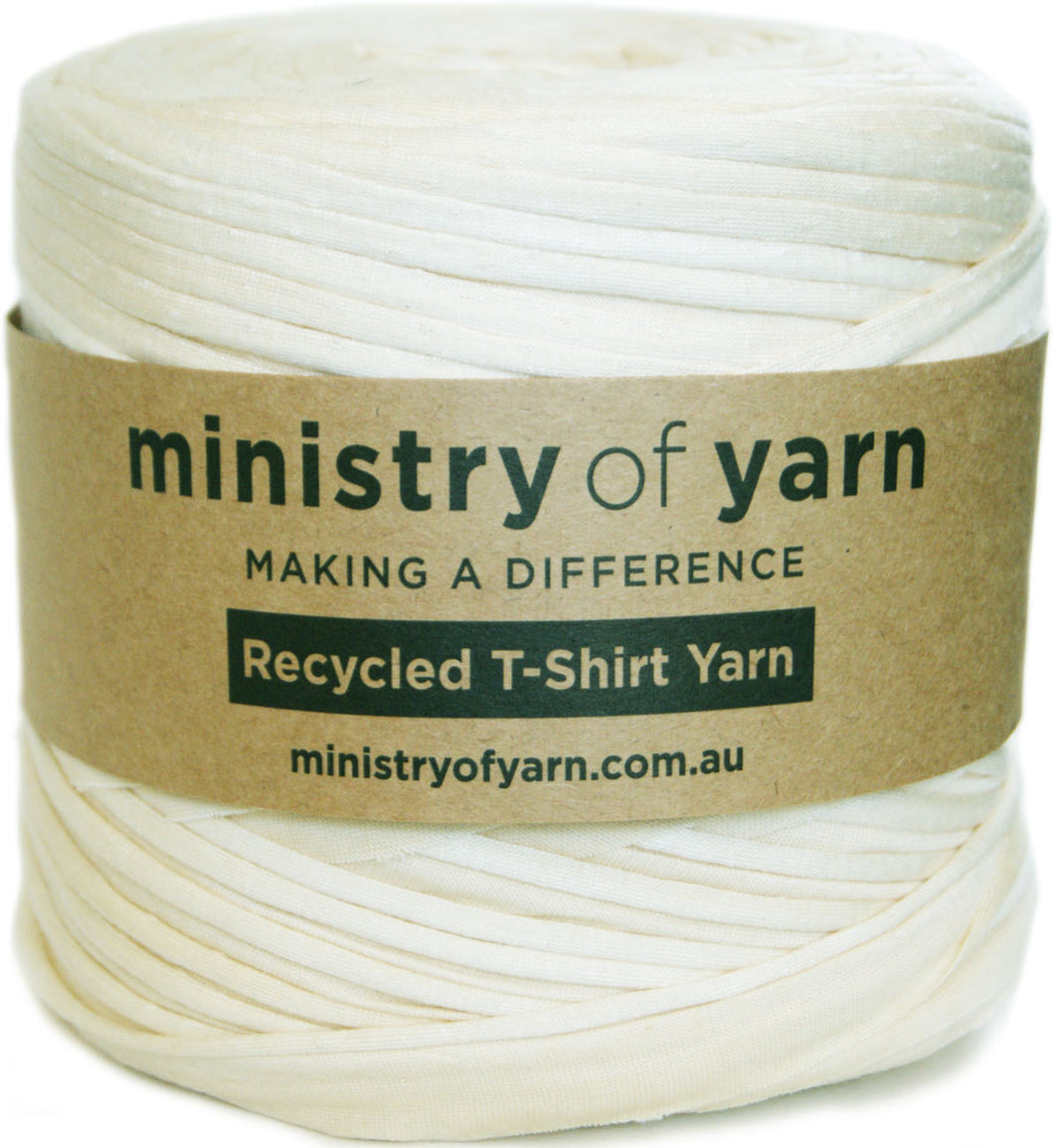 A spool of off-white recycled T-shirt yarn wrapped with a brown paper label that reads 'ministry of yarn' and 'Recycled T-Shirt Yarn'.