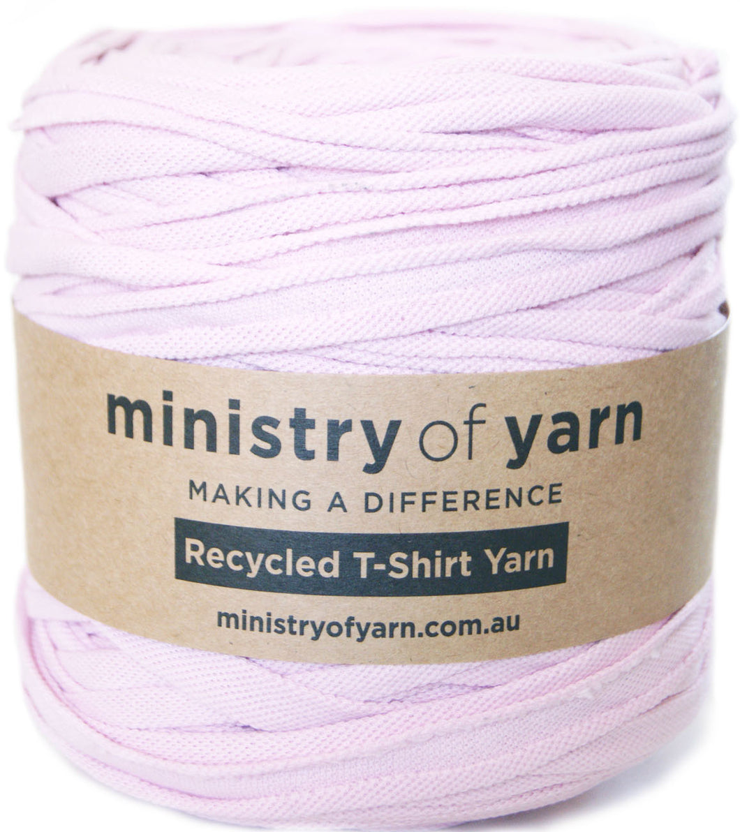 A ball of light pink recycled T-shirt yarn wrapped with a brown paper label that reads 'ministry of yarn'.