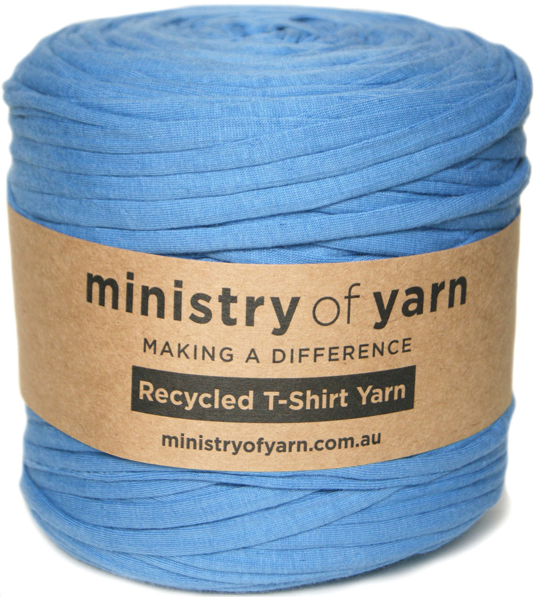 A ball of blue recycled T-shirt yarn wrapped in a brown kraft paper label that reads 'ministry of yarn' and 'Recycled T-Shirt Yarn'.
