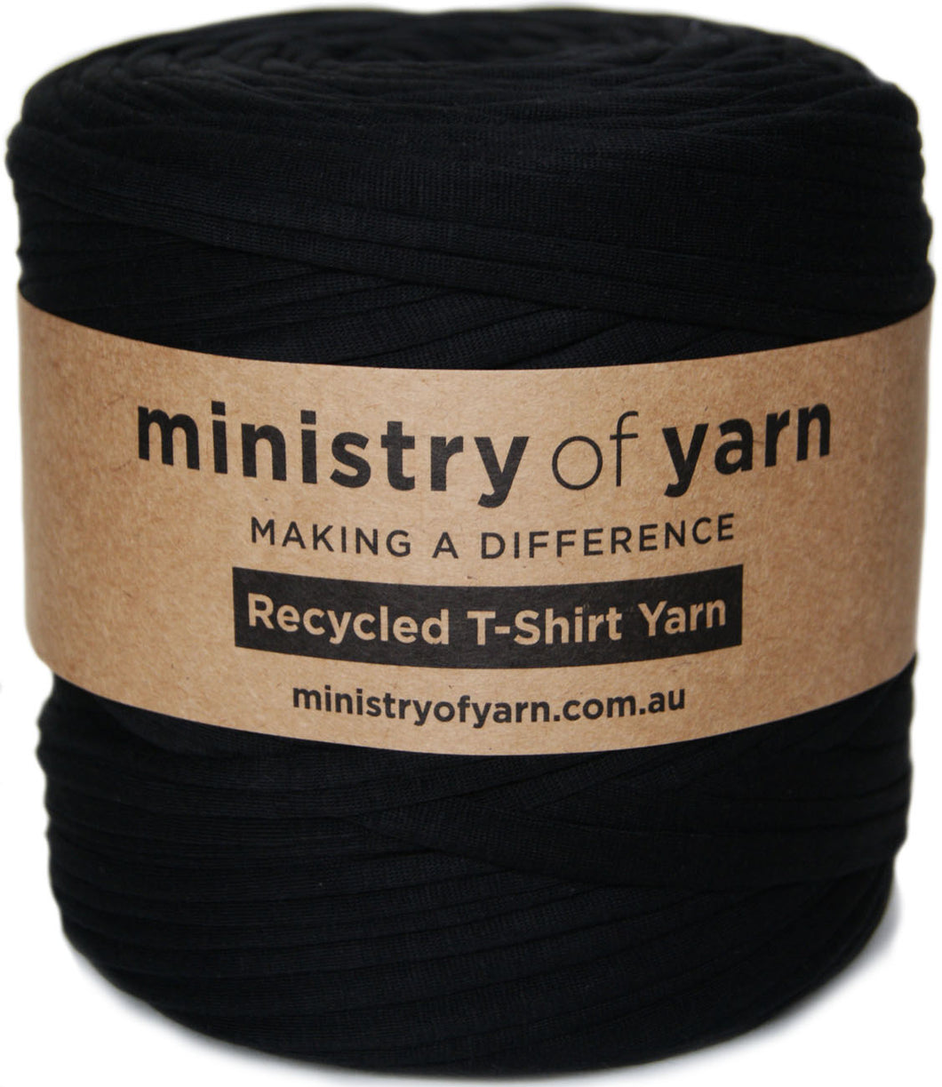 A roll of black recycled T-shirt yarn wrapped with a brown kraft paper label that reads 'ministry of yarn' and 'Recycled T-Shirt Yarn'.