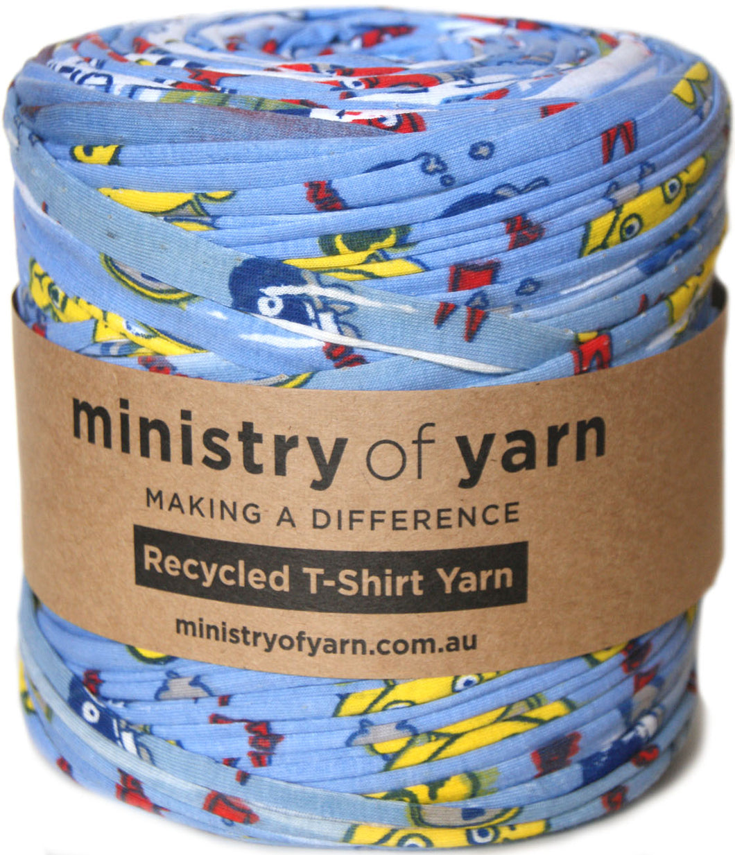 A roll of blue recycled T-shirt yarn with a colorful cartoon print, wrapped in a brown paper band labeled 'ministry of yarn'.