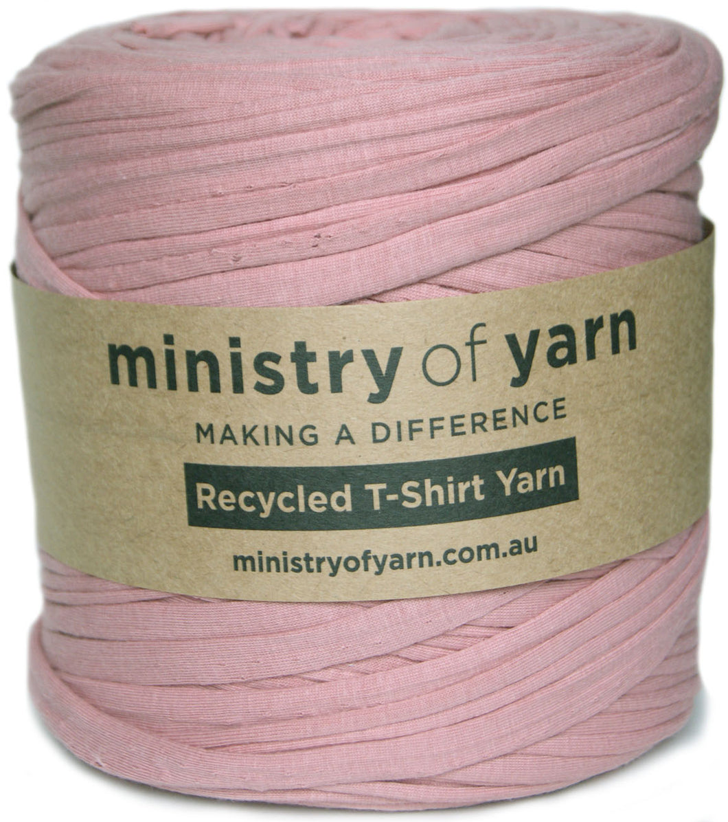 A skein of dusty pink recycled T-shirt yarn wrapped in a kraft paper label that reads 'ministry of yarn'.