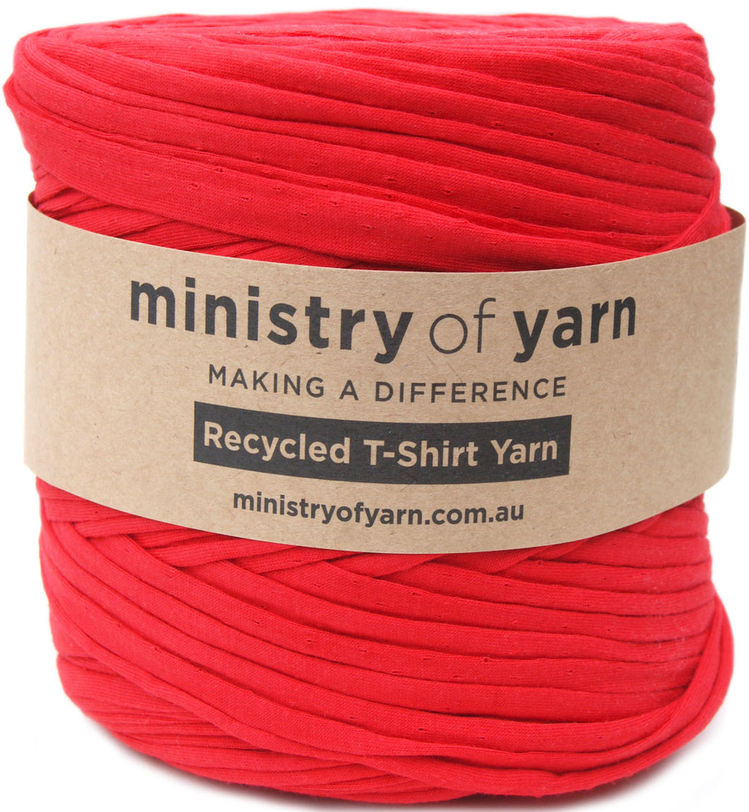 A skein of bright red recycled T-shirt yarn wrapped in a brown kraft paper label that reads 'ministry of yarn'.