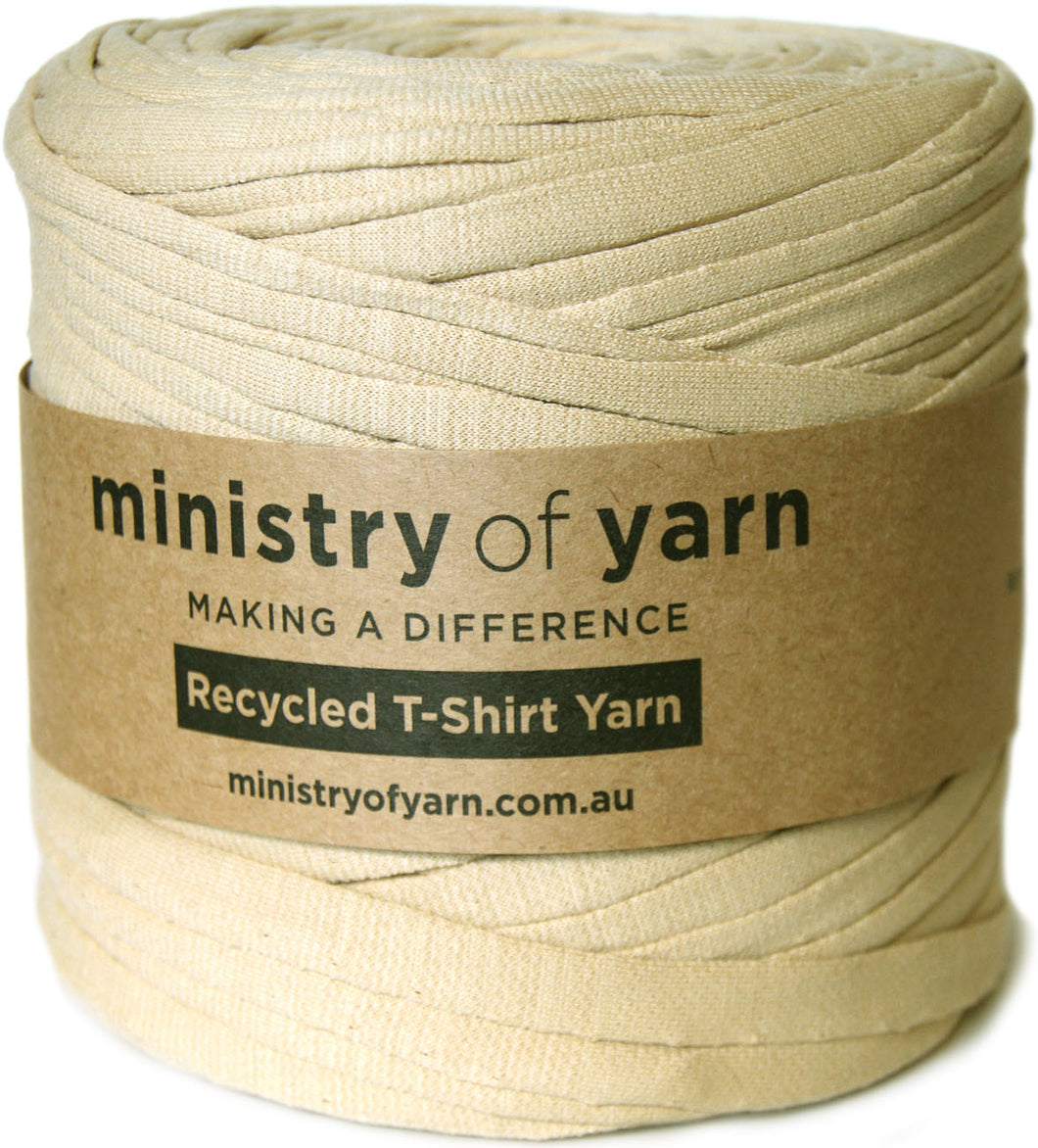 A spool of beige recycled T-shirt yarn wrapped in a brown paper band labeled 'ministry of yarn'.