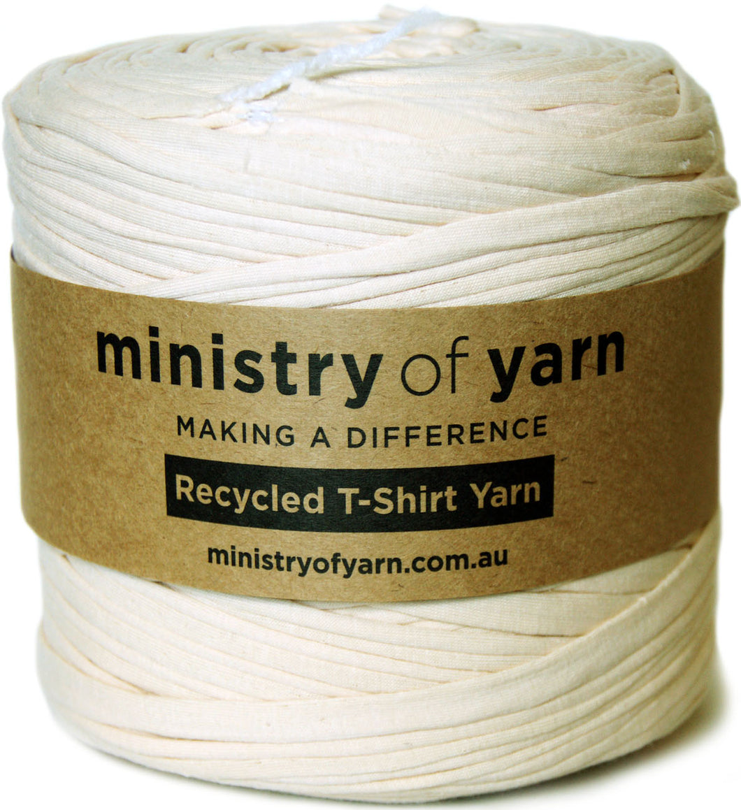 A spool of buff recycled t-shirt yarn wrapped with a brown paper label that reads 'ministry of yarn'.