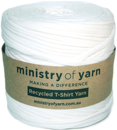 A spool of white Ministry of Yarn recycled T-shirt yarn wrapped in a brown paper band, shown on a white background.