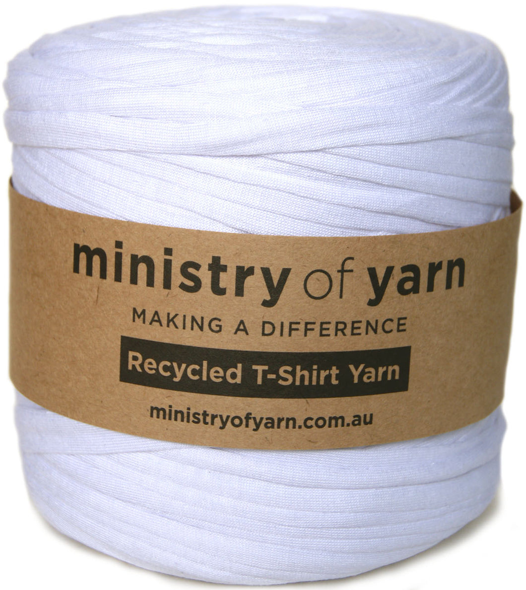 A white spool of Ministry of Yarn recycled T-shirt yarn wrapped with a brown kraft paper label, shown against a plain white background.
