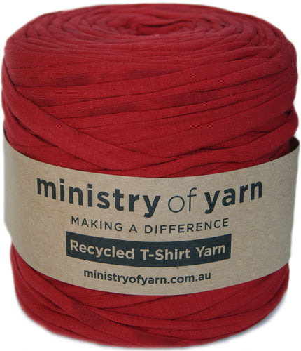 A roll of red recycled T-shirt yarn wrapped in a kraft paper label that reads 'ministry of yarn'.
