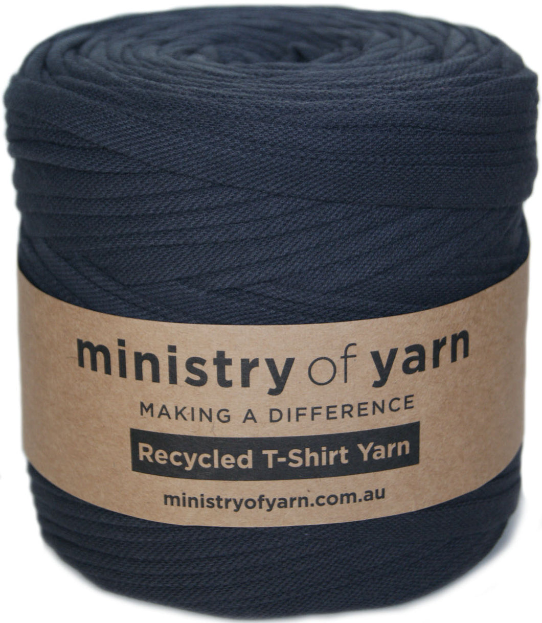 A roll of dark grey recycled T-shirt yarn wrapped with a brown paper label that reads 'ministry of yarn'.