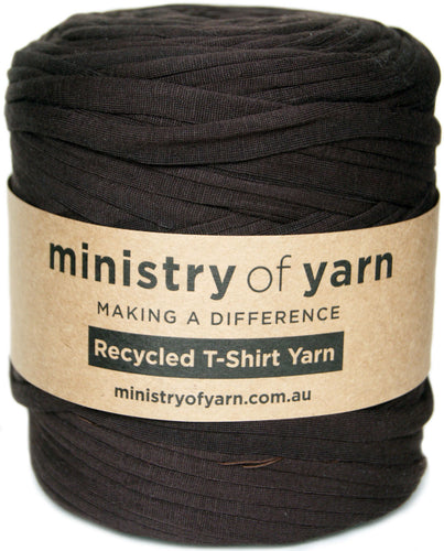 A large spool of dark brown recycled T-shirt yarn wrapped with a kraft paper label that reads 'ministry of yarn'.