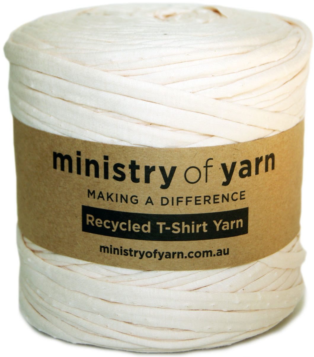 A spool of off-white recycled T-shirt yarn wrapped with a brown paper label that reads 'ministry of yarn' and 'Recycled T-Shirt Yarn'.