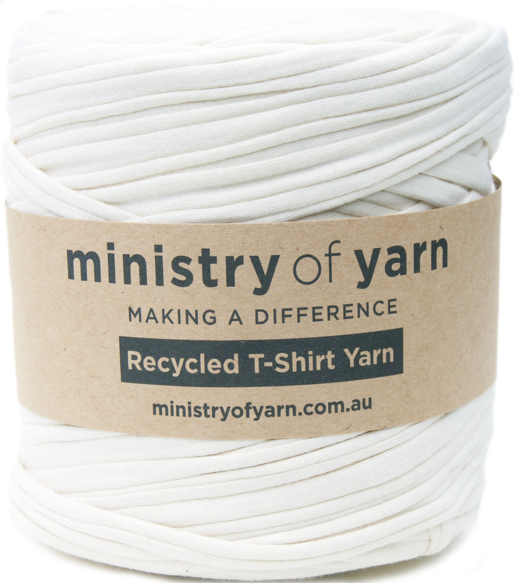 A spool of off-white recycled T-shirt yarn wrapped with a brown kraft paper label that reads 'ministry of yarn'.
