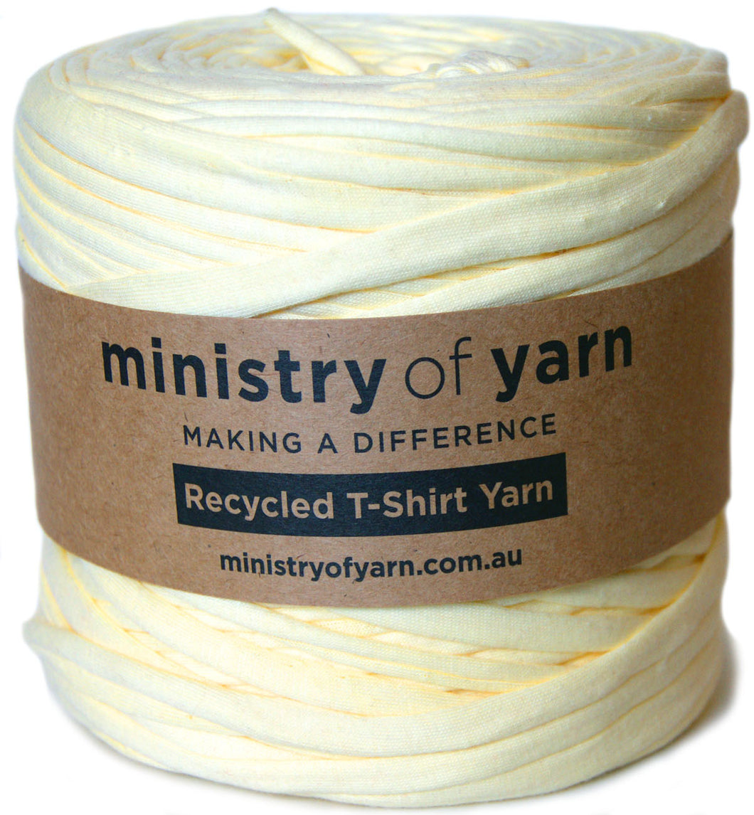 A roll of pale yellow-colored recycled T-shirt yarn wrapped with a brown paper label that reads 'ministry of yarn'.