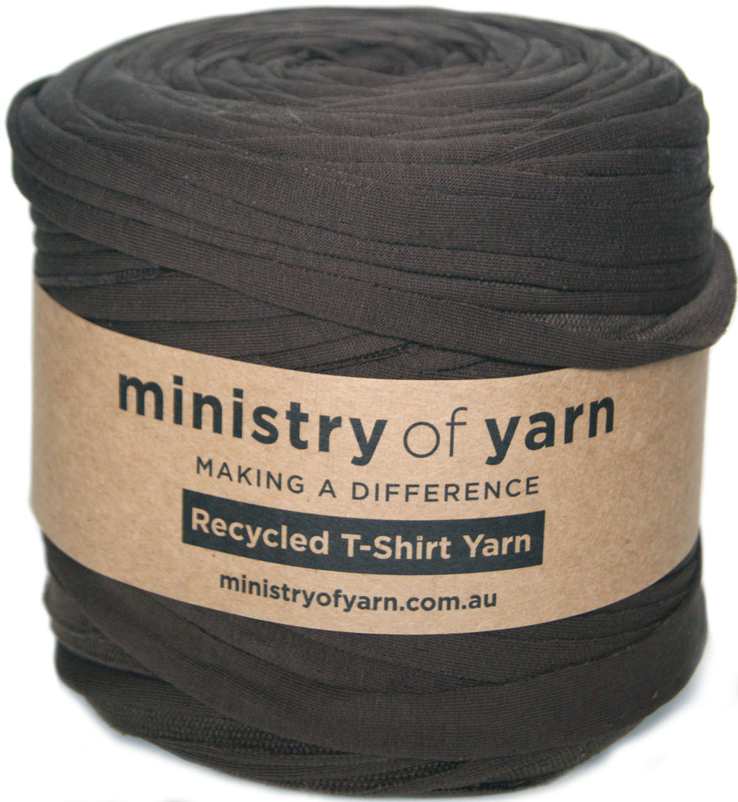 A roll of dark brown recycled T-shirt yarn wrapped in a brown paper band labeled 'ministry of yarn'.