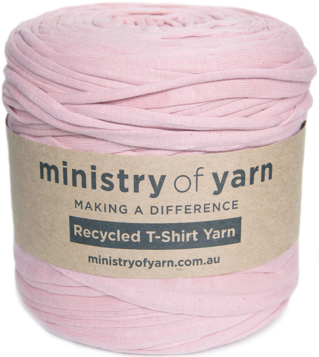 A skein of light pink recycled T-shirt yarn wrapped in a kraft paper label that reads 'ministry of yarn' and 'Recycled T-Shirt Yarn'.