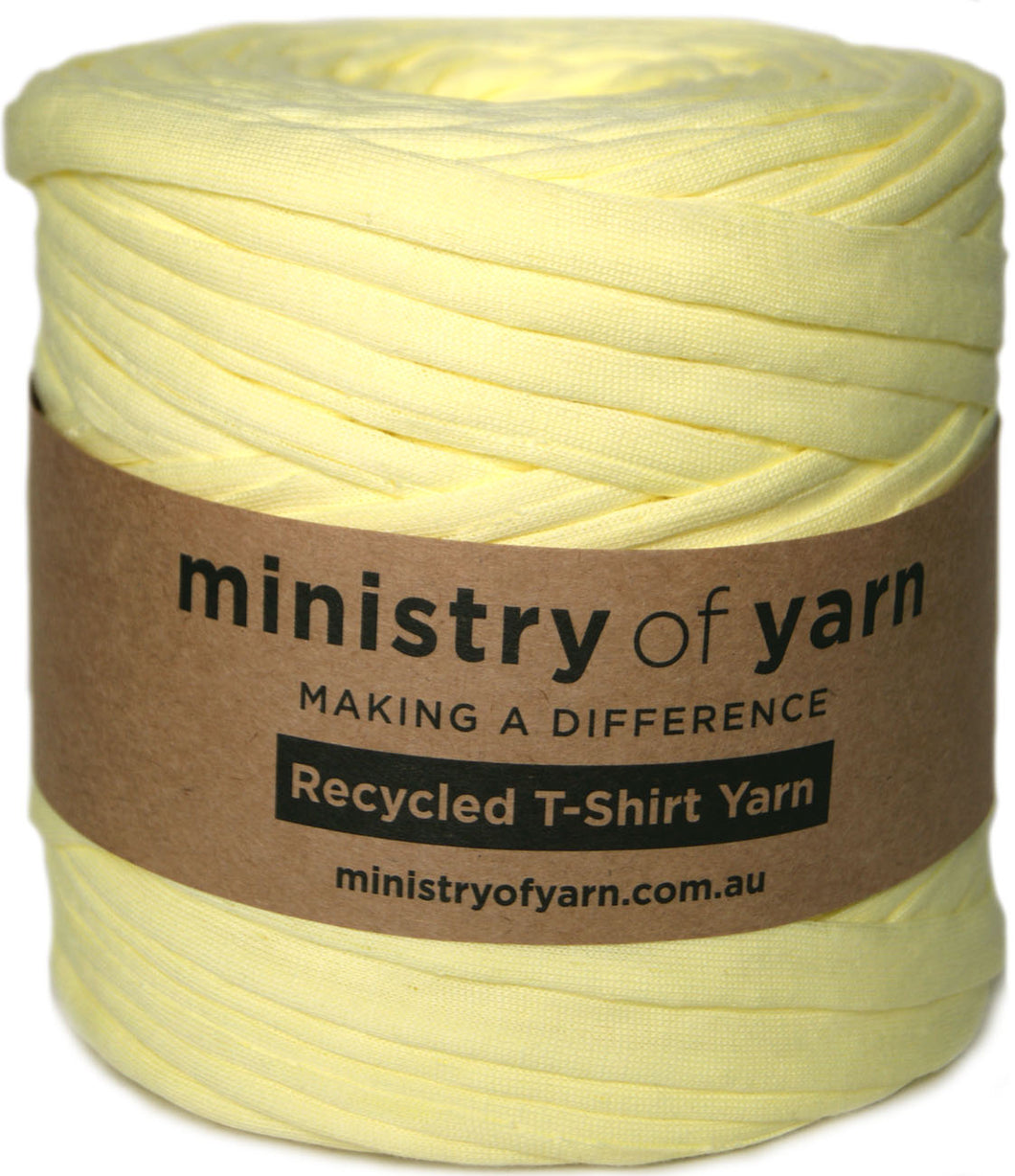 A large spool of pale yellow knit t-shirt yarn wrapped with a brown paper label that reads 'ministry of yarn'.