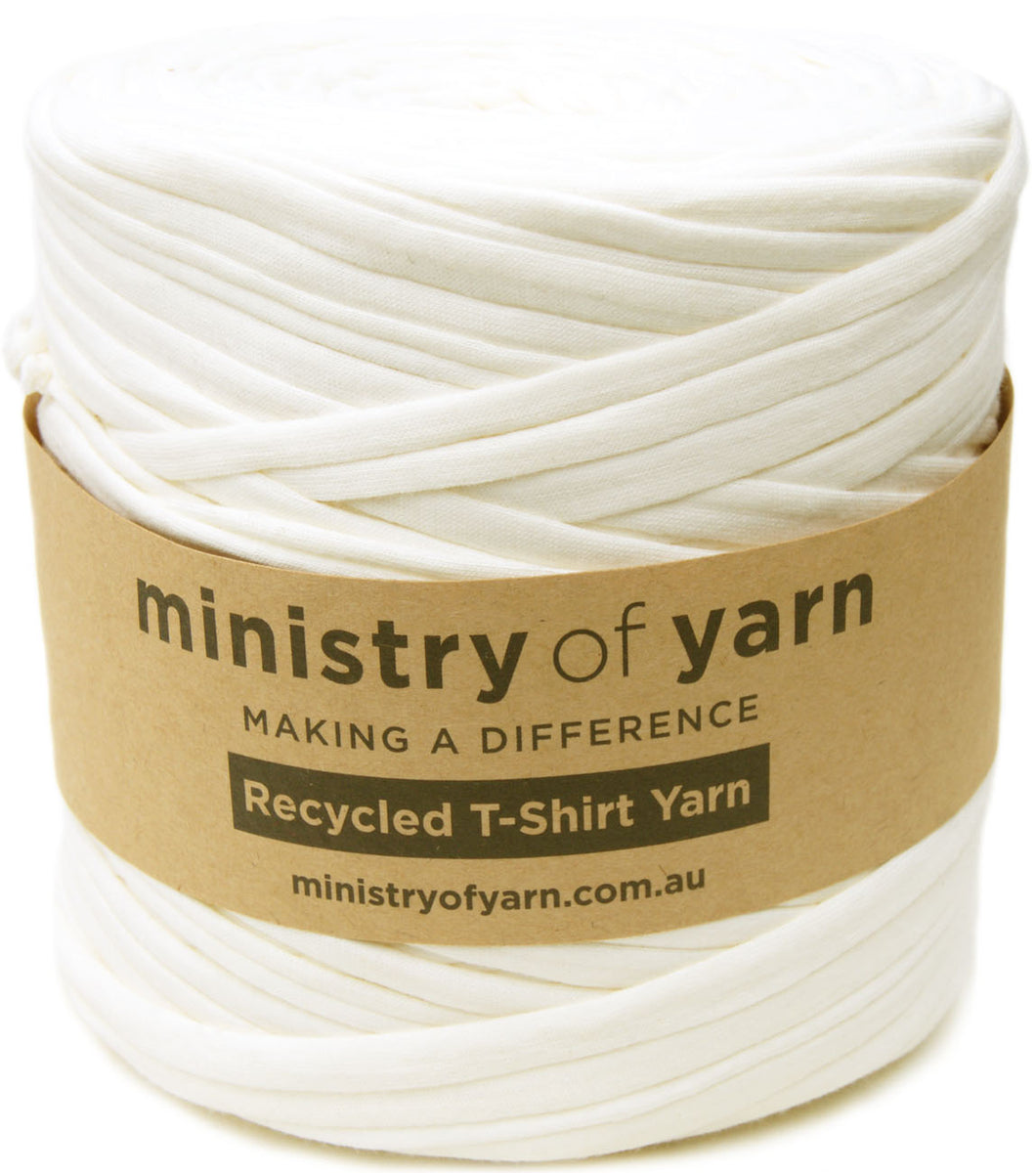 A spool of off-white recycled T-shirt yarn wrapped in a brown paper band labeled 'ministry of yarn'.