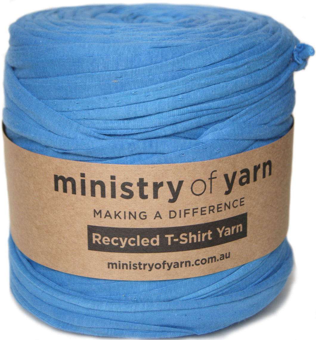 A roll of bright blue recycled T-shirt yarn wrapped with a brown paper label that reads 'ministry of yarn' and 'Recycled T-Shirt Yarn'.