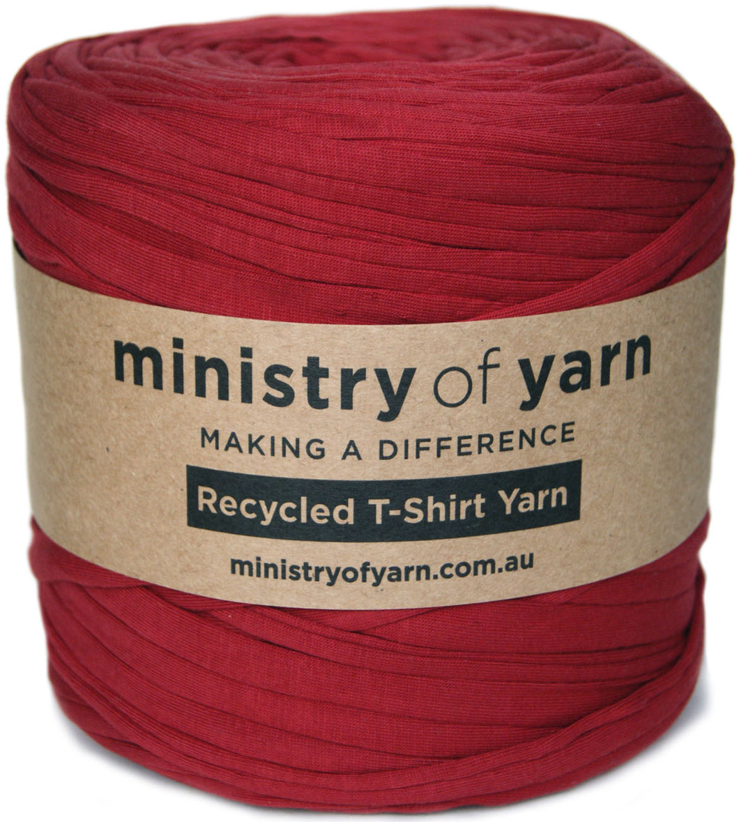 A ball of red recycled T-shirt yarn wrapped in a brown kraft paper label that reads 'ministry of yarn'.