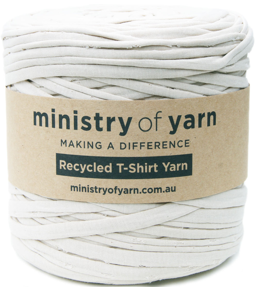 A spool of light tan recycled T-shirt yarn wrapped in a brown kraft paper label that reads 'ministry of yarn' and 'Recycled T-Shirt Yarn'.