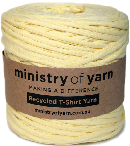 A spool of pale yellow recycled T-shirt yarn wrapped in a brown paper label that reads 'ministry of yarn' and 'Recycled T-Shirt Yarn'.