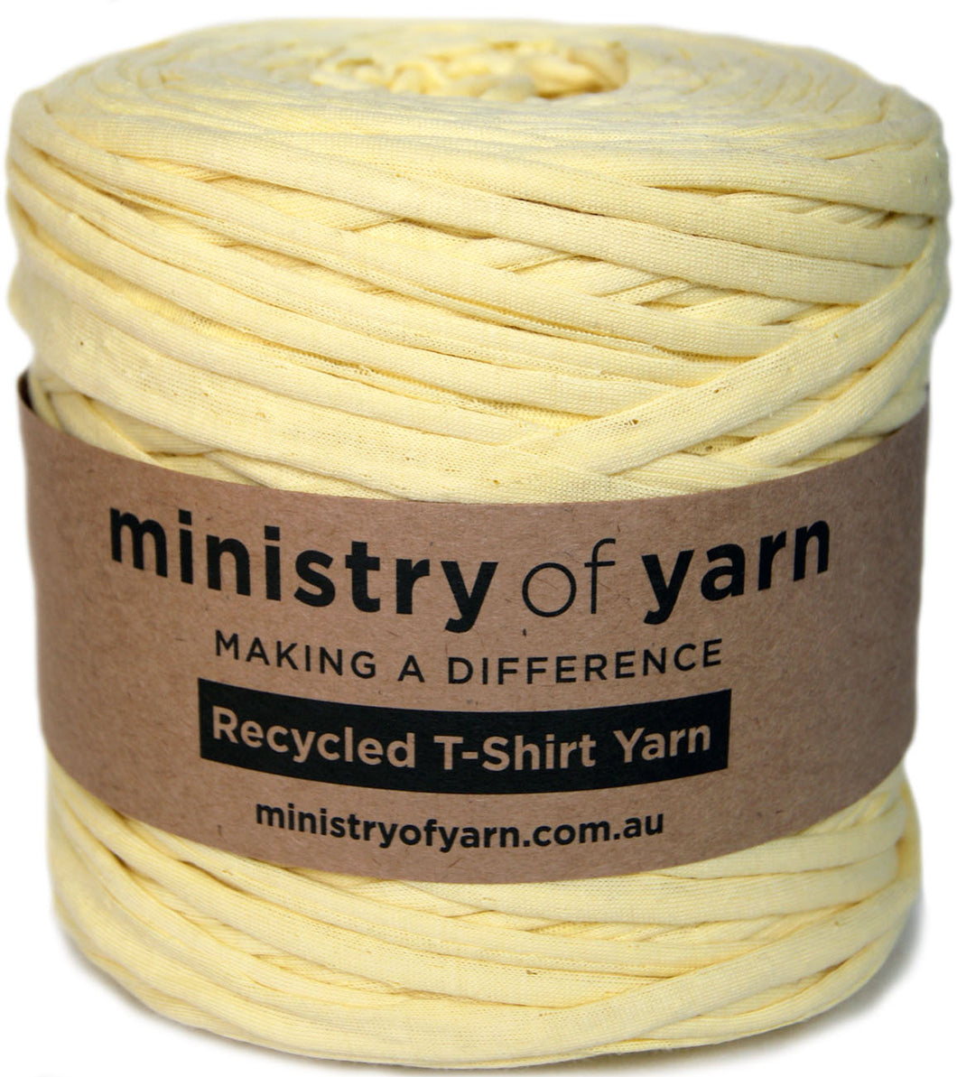 A spool of pale yellow recycled T-shirt yarn wrapped in a brown paper label that reads 'ministry of yarn' and 'Recycled T-Shirt Yarn'.