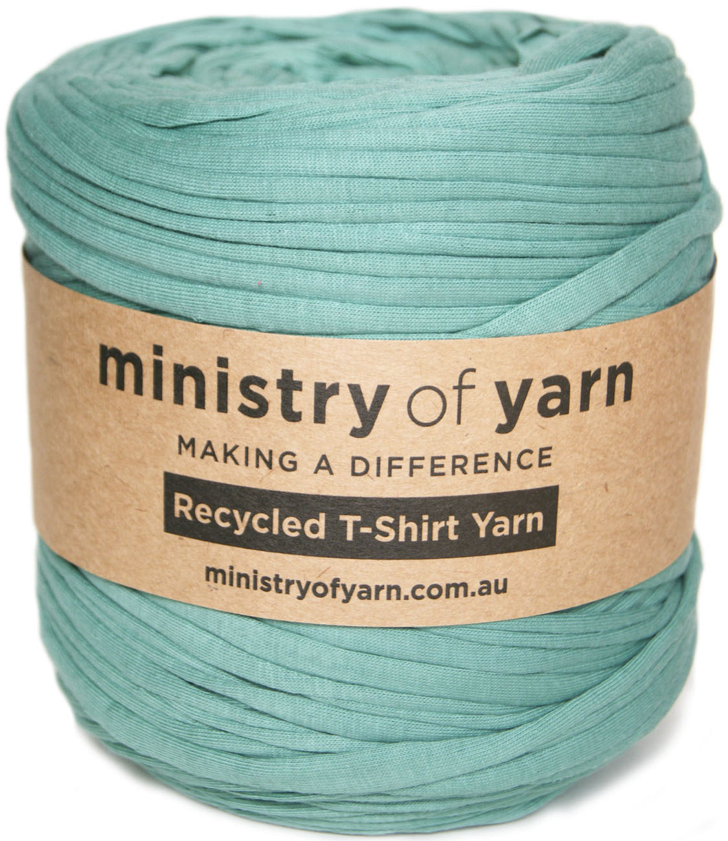 A ball of mint green recycled T-shirt yarn wrapped with a brown kraft paper label that reads 'ministry of yarn'.