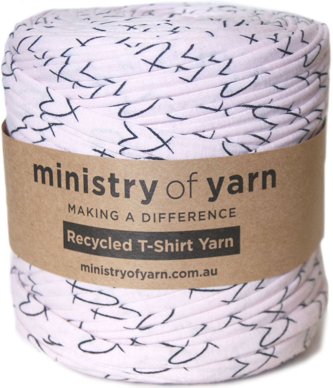 A roll of Ministry of Yarn recycled T-shirt yarn with a light pink base and black heart pattern, wrapped in a brown paper label.