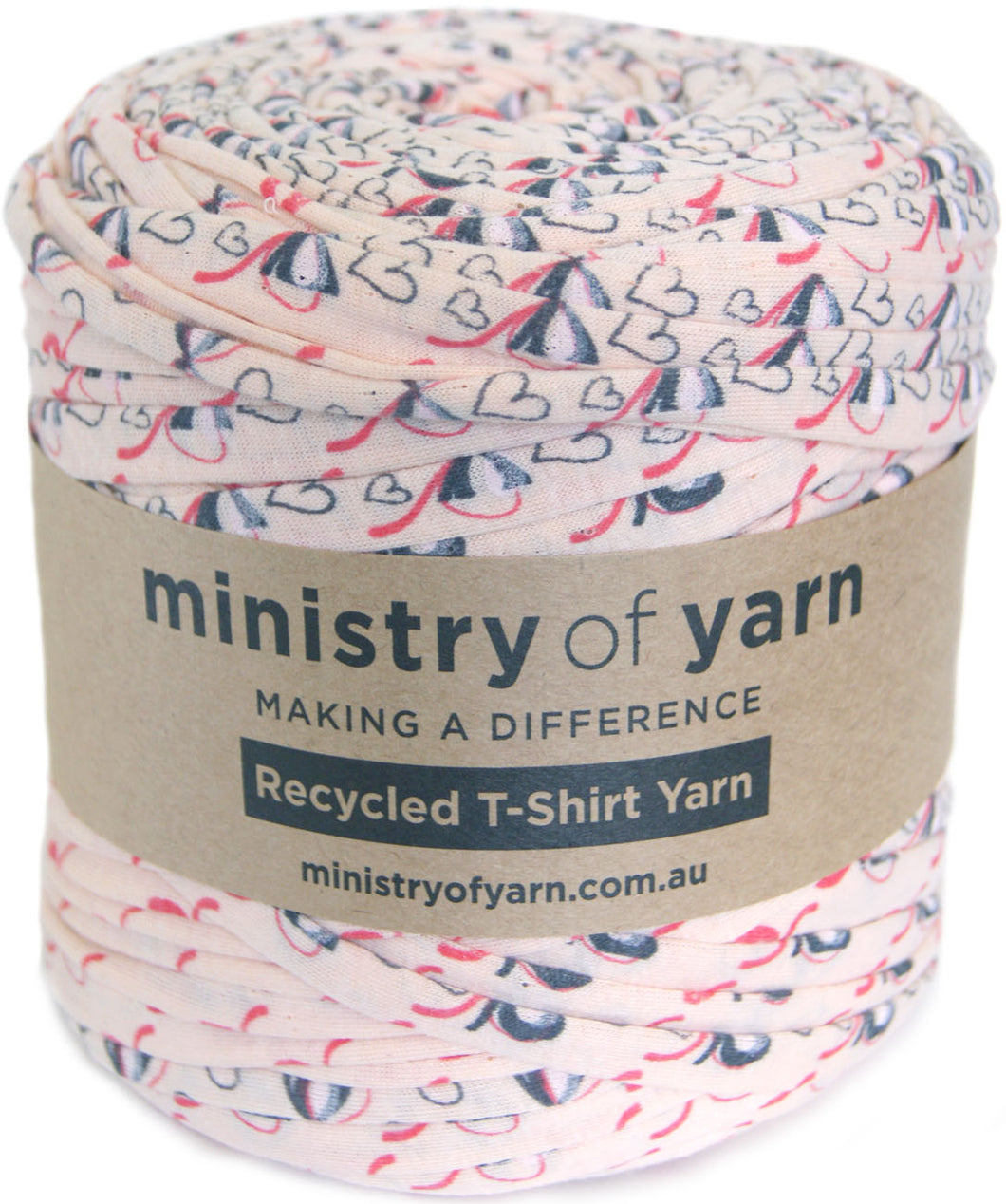 A roll of Ministry of Yarn recycled T-shirt yarn with a peach, navy, and pink pattern, wrapped in a brown paper label.