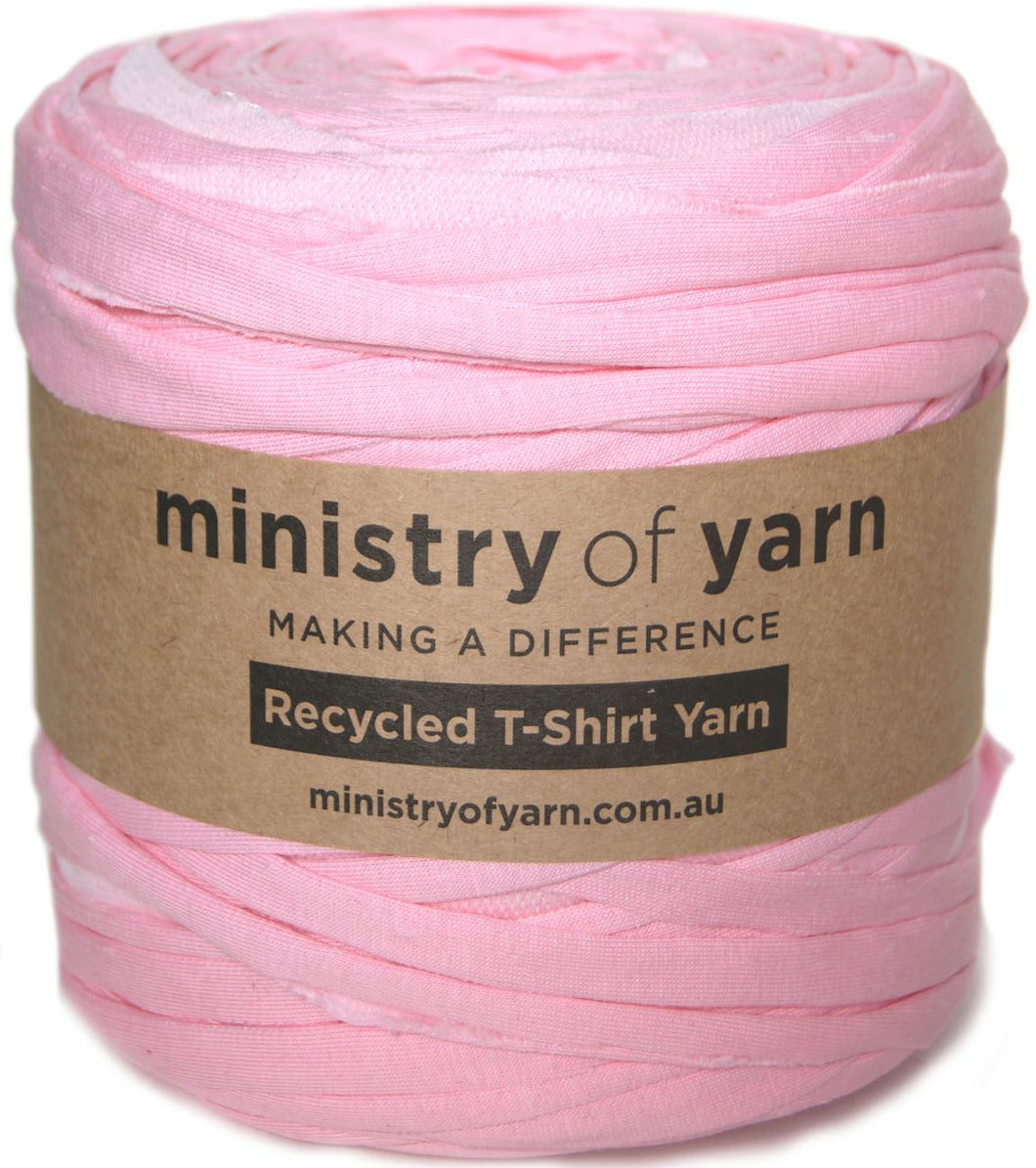 A roll of light pink recycled T-shirt yarn wrapped in a brown paper label that reads 'ministry of yarn'.