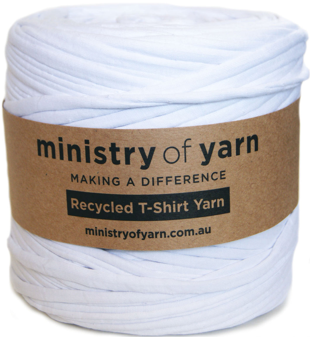 A spool of white recycled T-shirt yarn wrapped with a brown kraft paper label that reads 'ministry of yarn'.