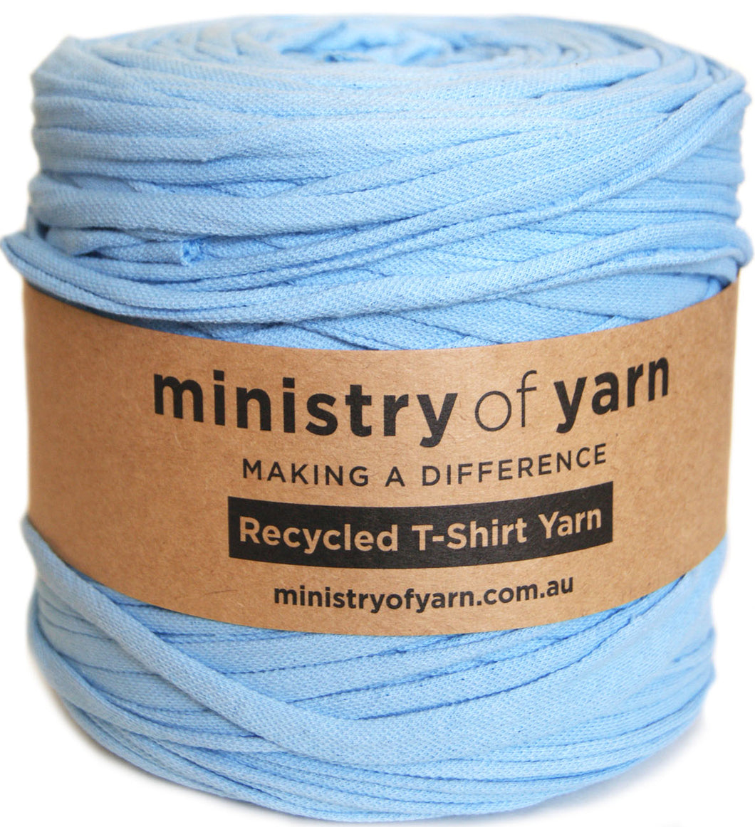 A spool of light blue recycled T-shirt yarn wrapped in a brown paper label that reads 'ministry of yarn'.