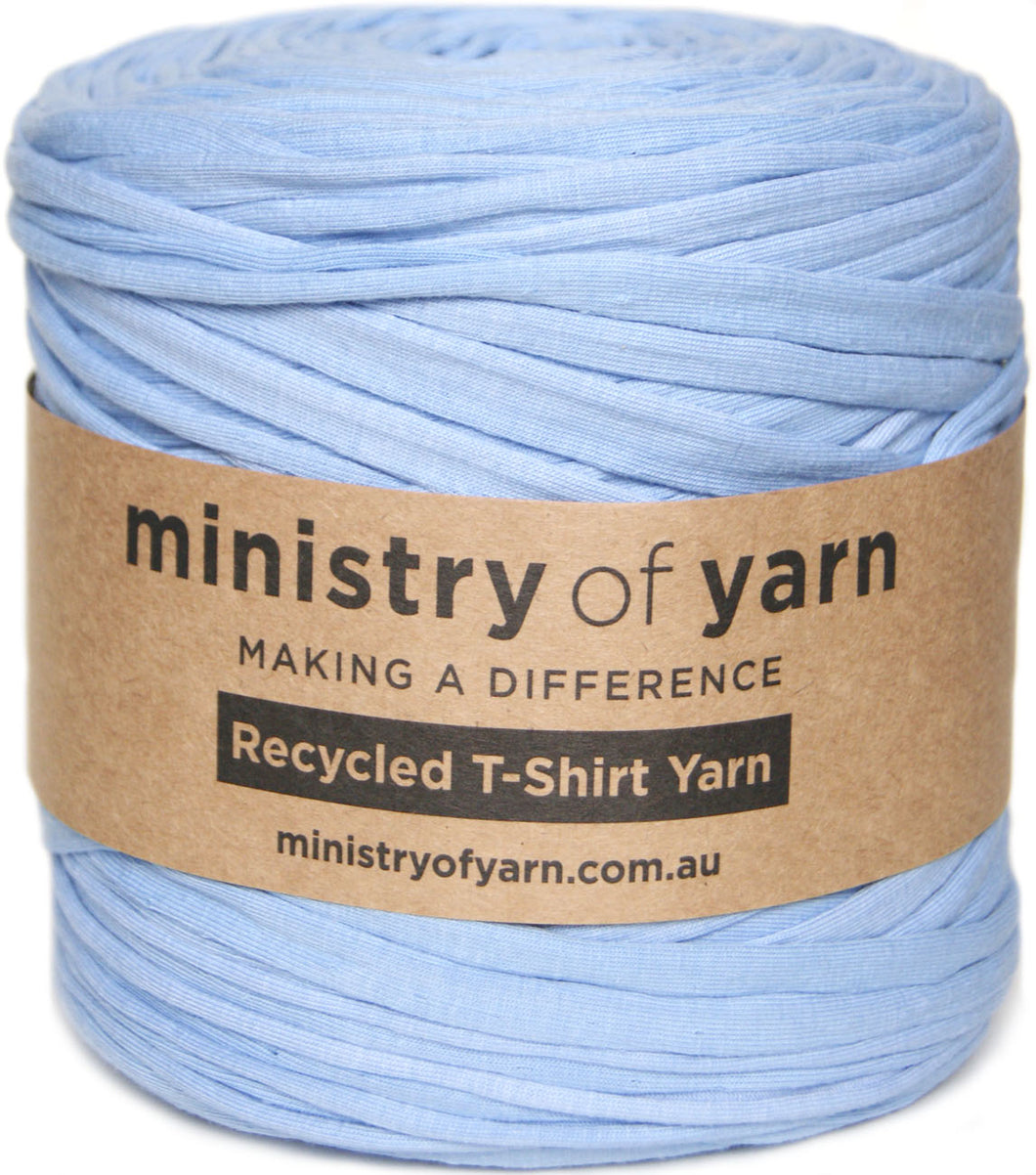 A spool of light blue recycled T-shirt yarn wrapped with a brown paper label that reads 'ministry of yarn'.