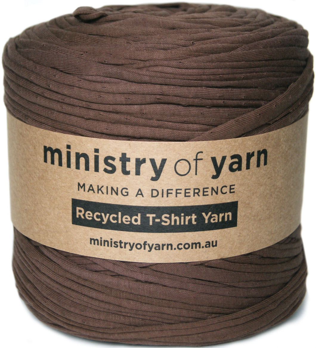 A large spool of brown recycled T-shirt yarn wrapped with a kraft paper label that reads 'ministry of yarn' and 'Recycled T-Shirt Yarn'.