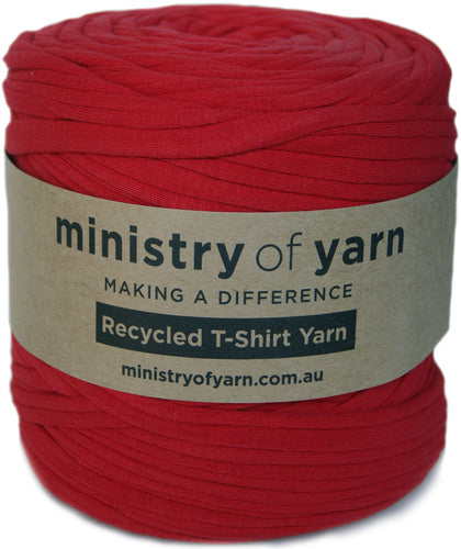 A large spool of red recycled T-shirt yarn with a brown paper label that reads 'ministry of yarn' and 'Recycled T-Shirt Yarn'.