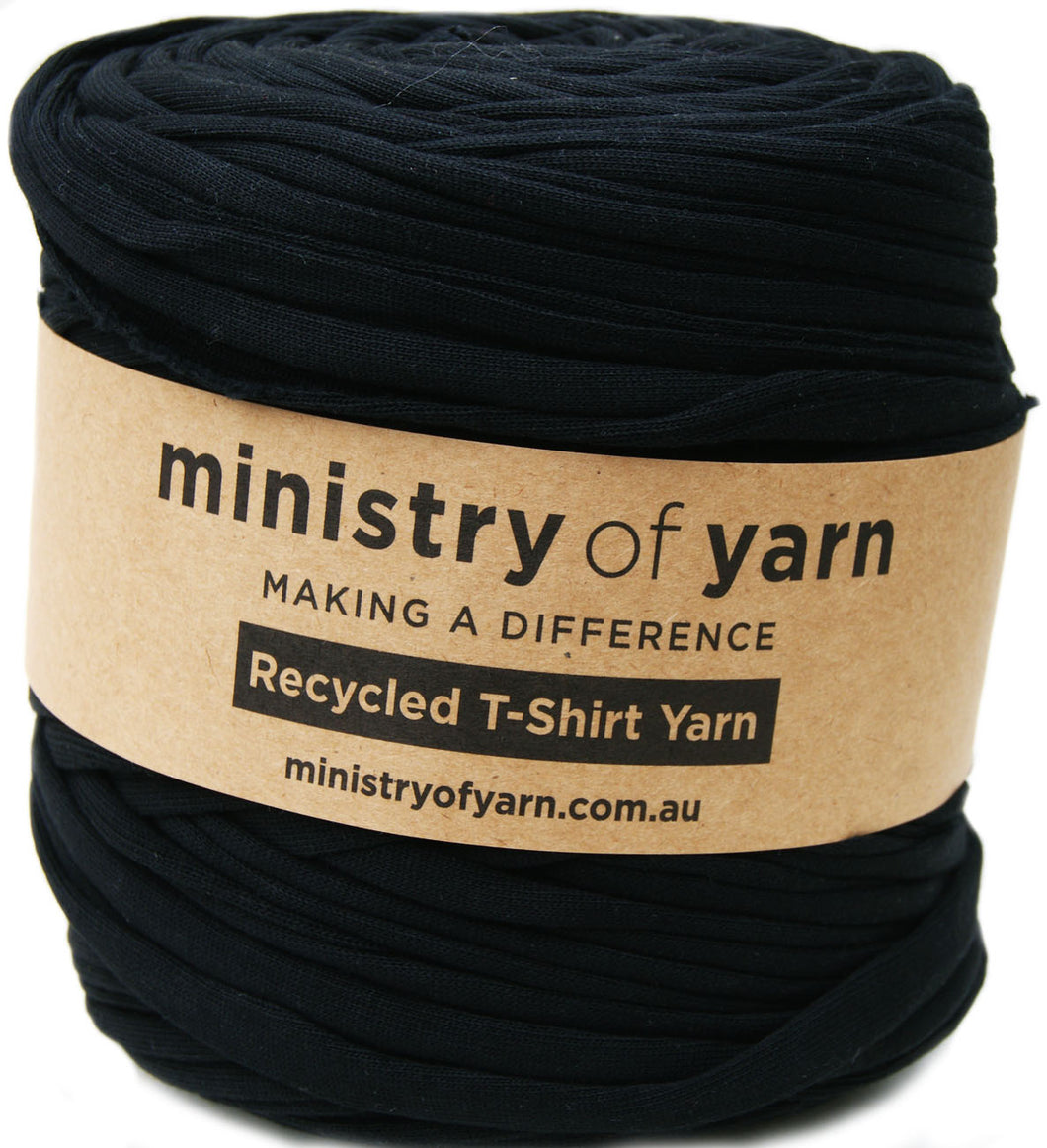 A spool of black recycled t-shirt yarn wrapped with a brown paper label that reads 'ministry of yarn'.