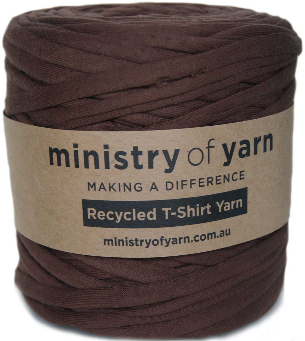 A ball of brown recycled T-shirt yarn wrapped with a kraft paper label that reads 'ministry of yarn' and 'Recycled T-Shirt Yarn'.