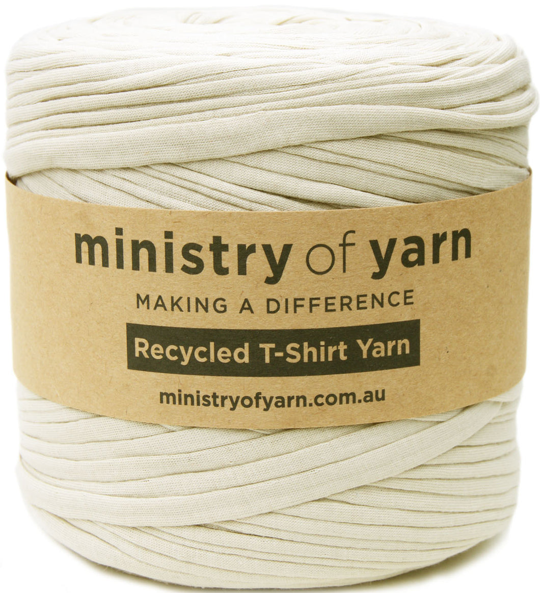 A large spool of beige recycled T-shirt yarn wrapped with a brown kraft paper label that reads 'ministry of yarn'.