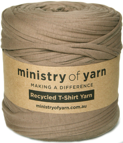 A roll of Ministry of Yarn recycled T-shirt yarn in a muted taupe-brown color, wrapped with a kraft paper label.