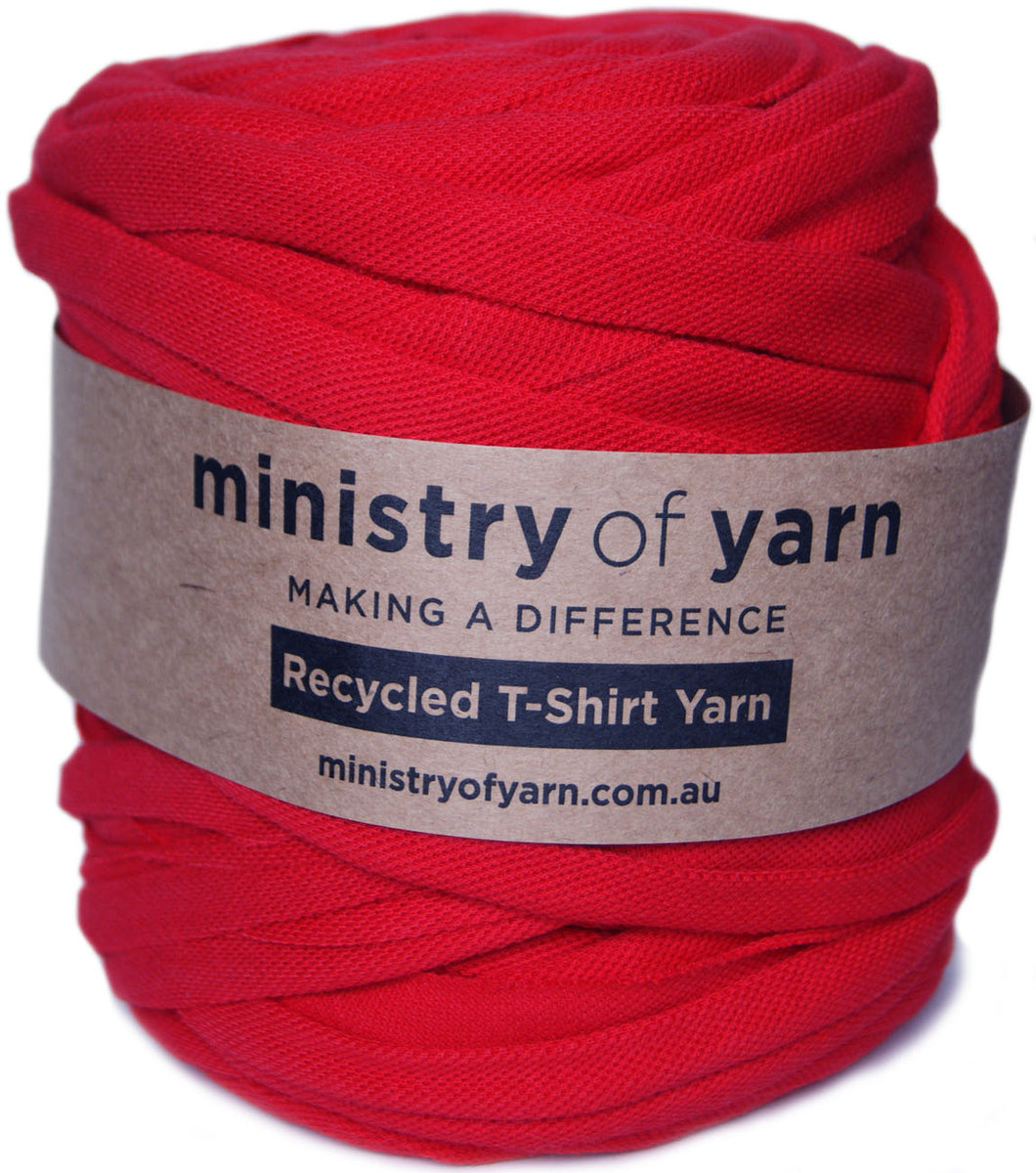 A ball of bright red recycled T-shirt yarn wrapped with a brown paper label that reads 'ministry of yarn' and 'Recycled T-Shirt Yarn'.